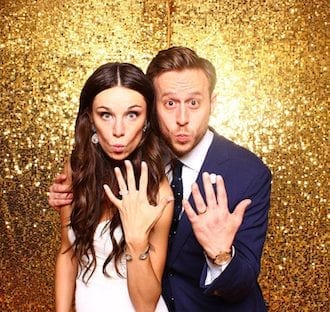 bride and groom in front of gold sparkle backdrop