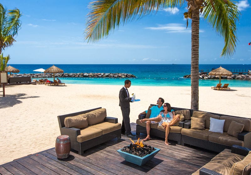 butler serving couple on the beach on honeymoon