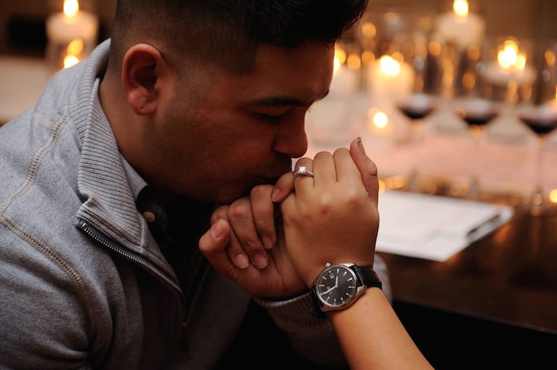 man kissing woman's fingers