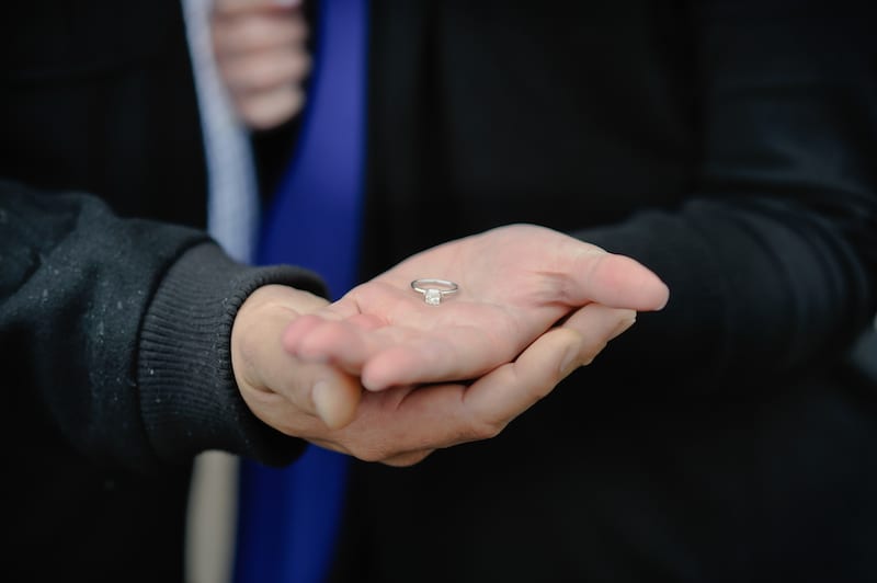 solitaire engagement ring in couples hands