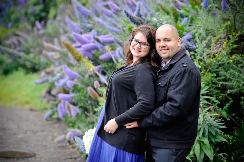 man and woman in front of purple flowers