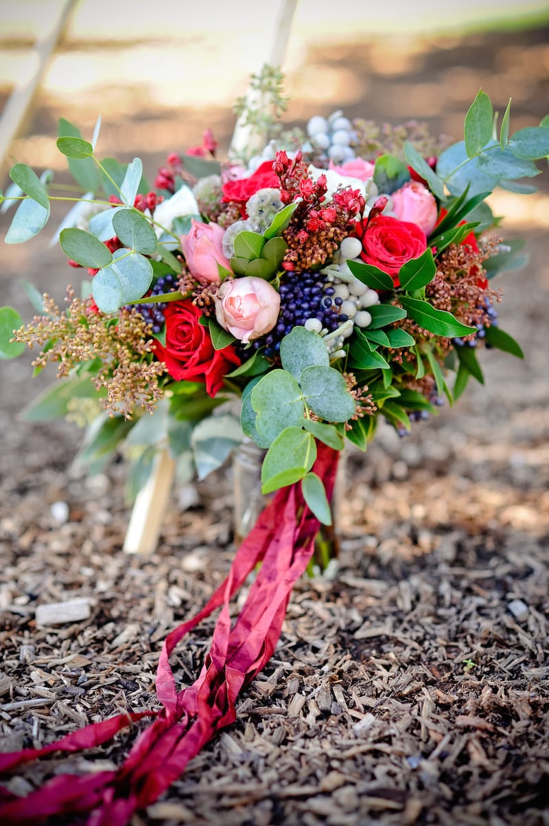lush bridal bouquet tied with maroon ribbon