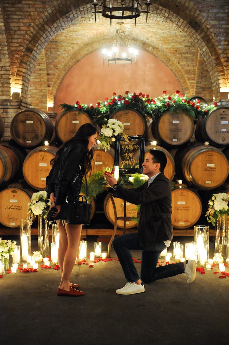 red roses candles wine barrels proposal