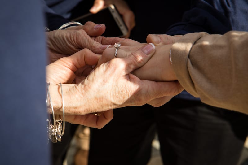 family looking at ring after she says yes