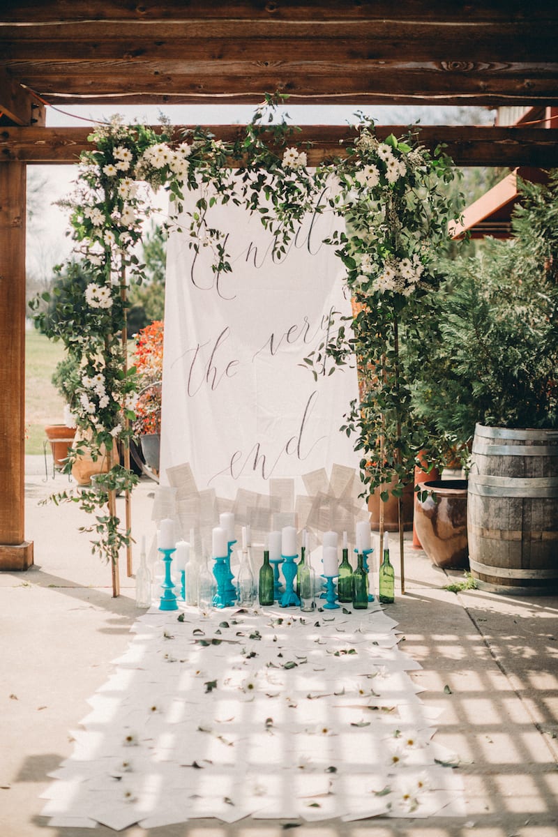 banner hanging from flower archway