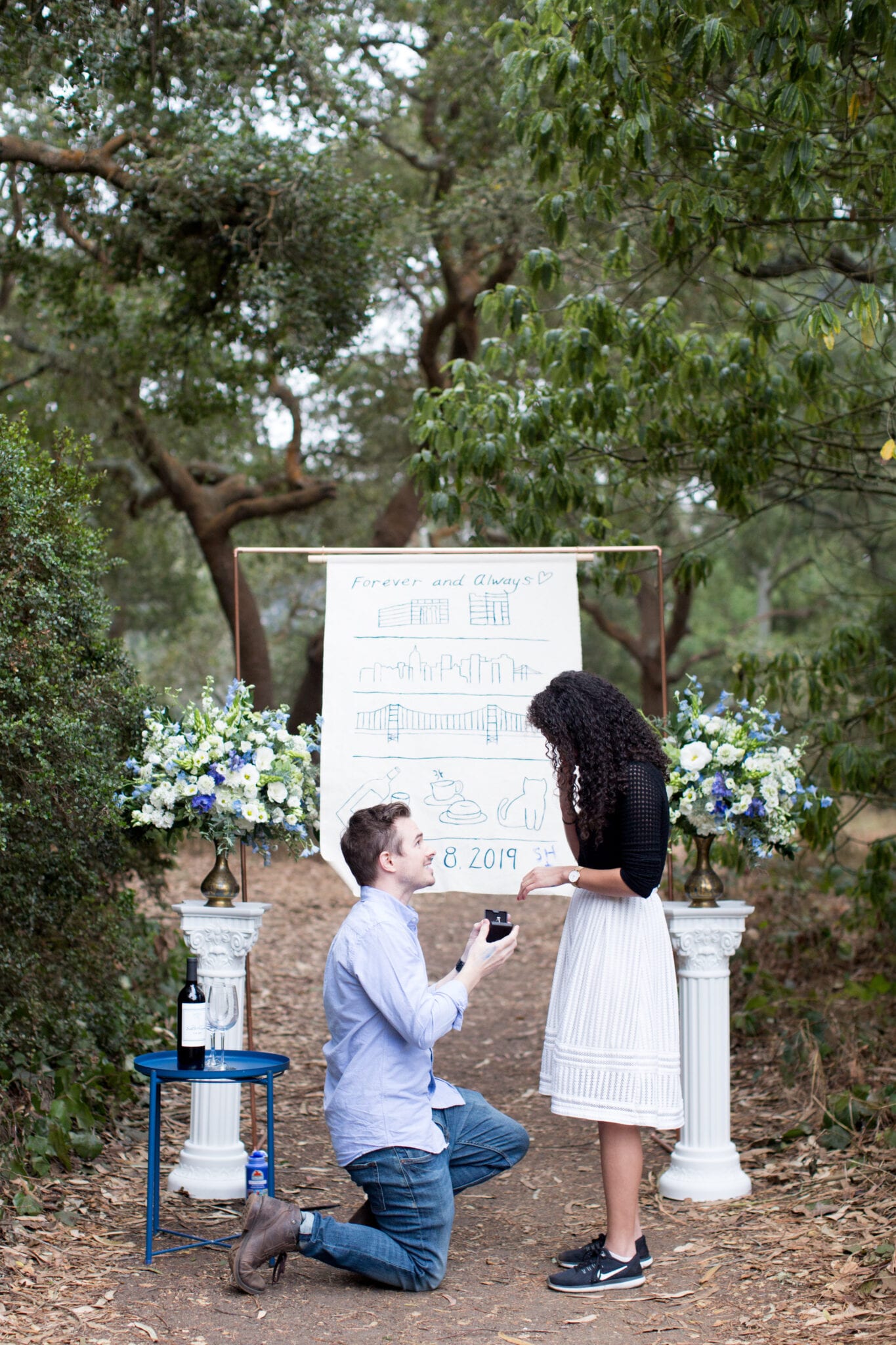 proposal in front of copper arch with banner