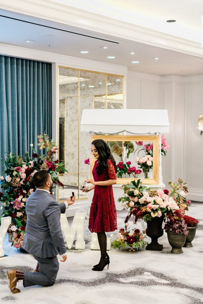 man proposing with red flowers
