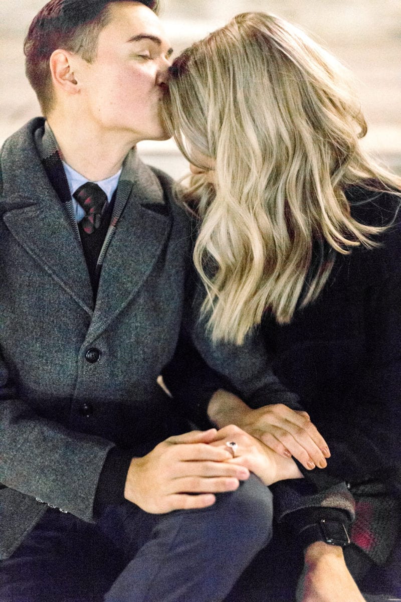 man kissing woman on forehead