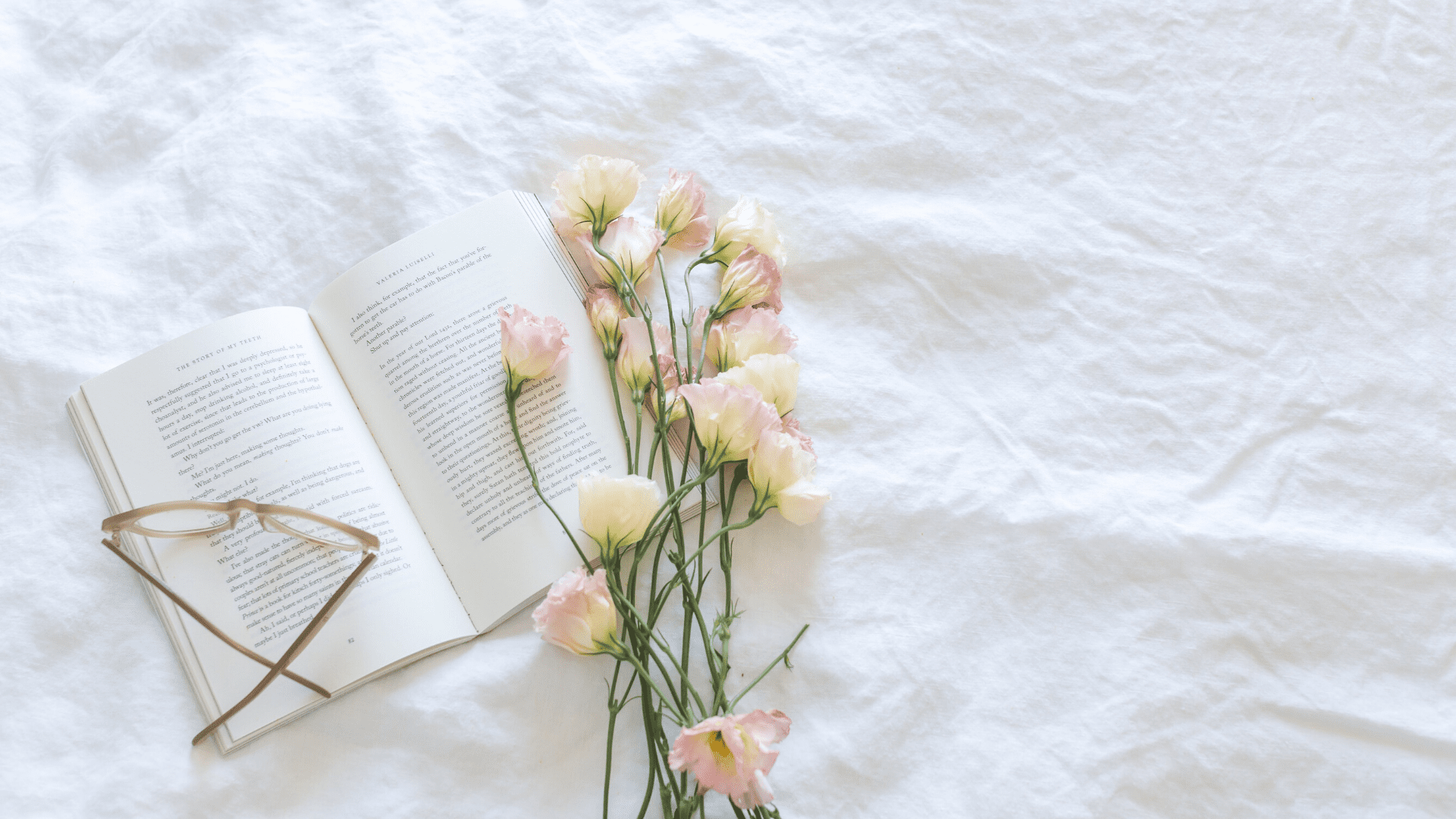 Book and flowers on bed
