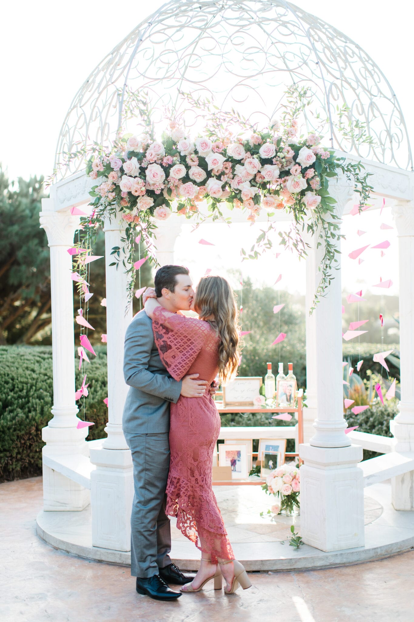 couple kissing in front of gazebo for engagement at monarch beach 