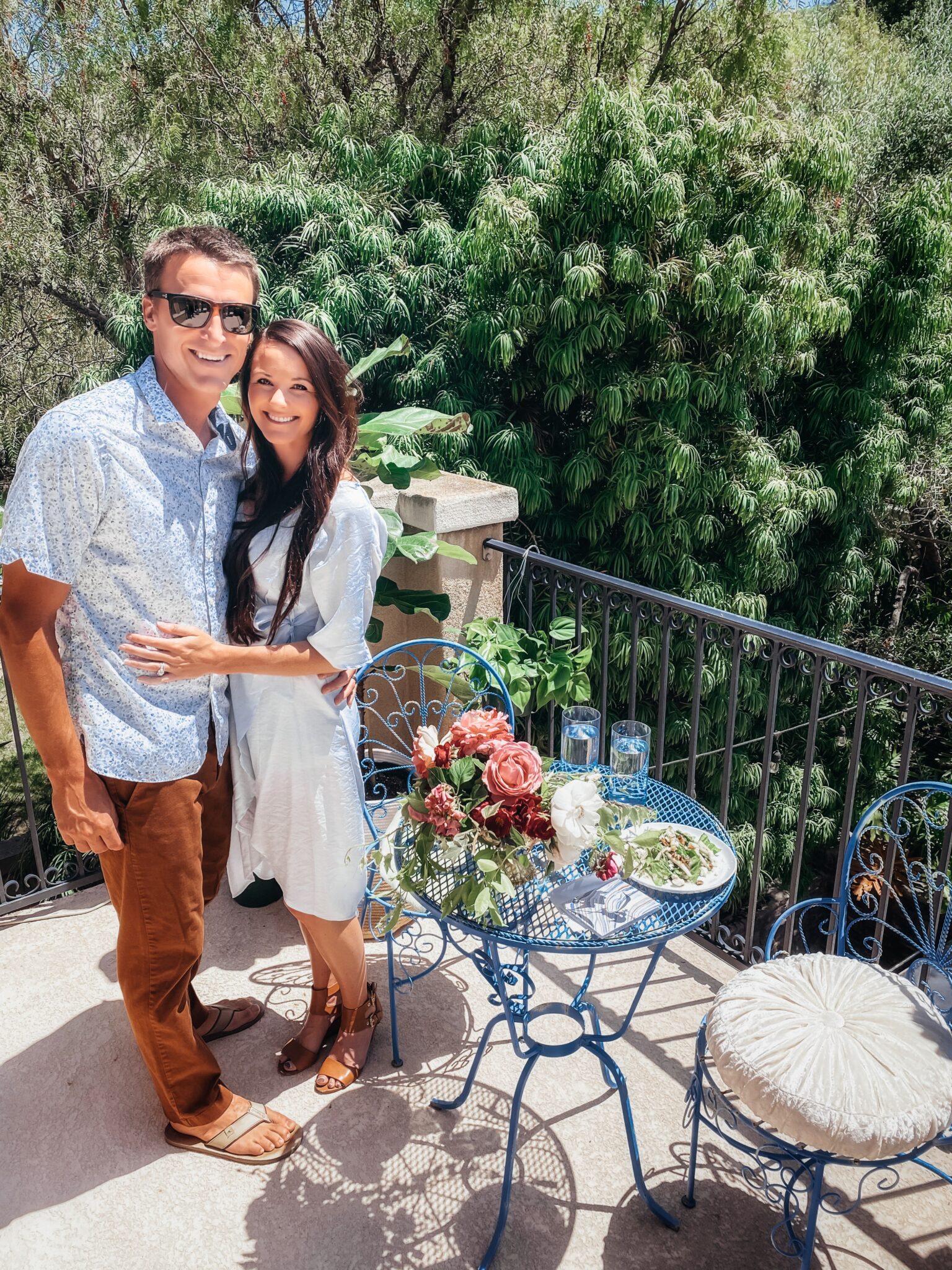 couple standing next to table on balcony