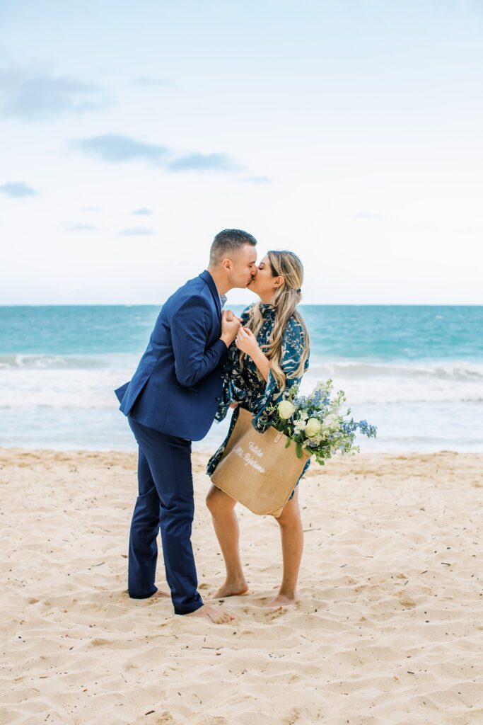 Couple kissing on beach after getting engaged