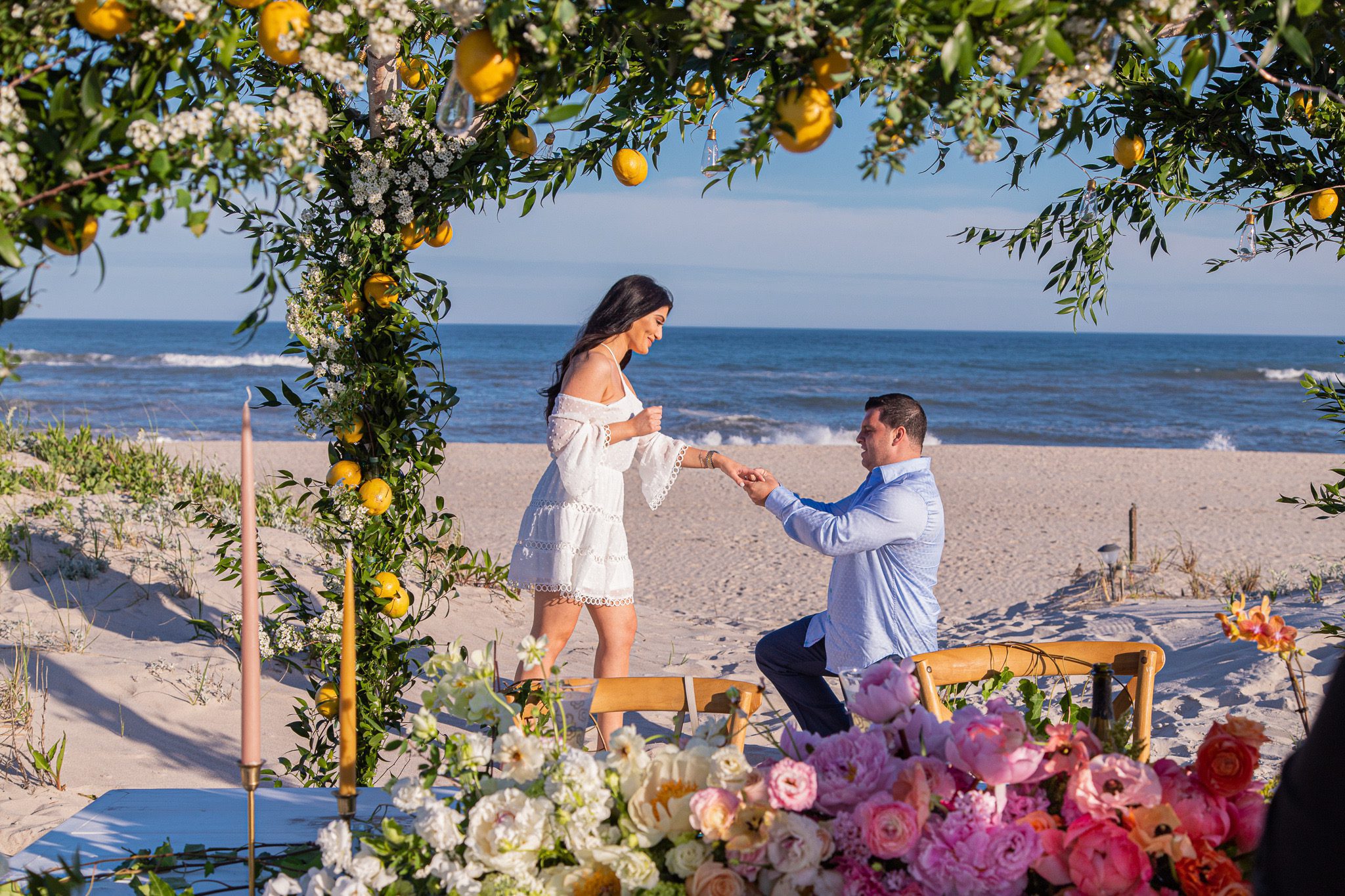 Man down on one knee on beach during marriage proposal