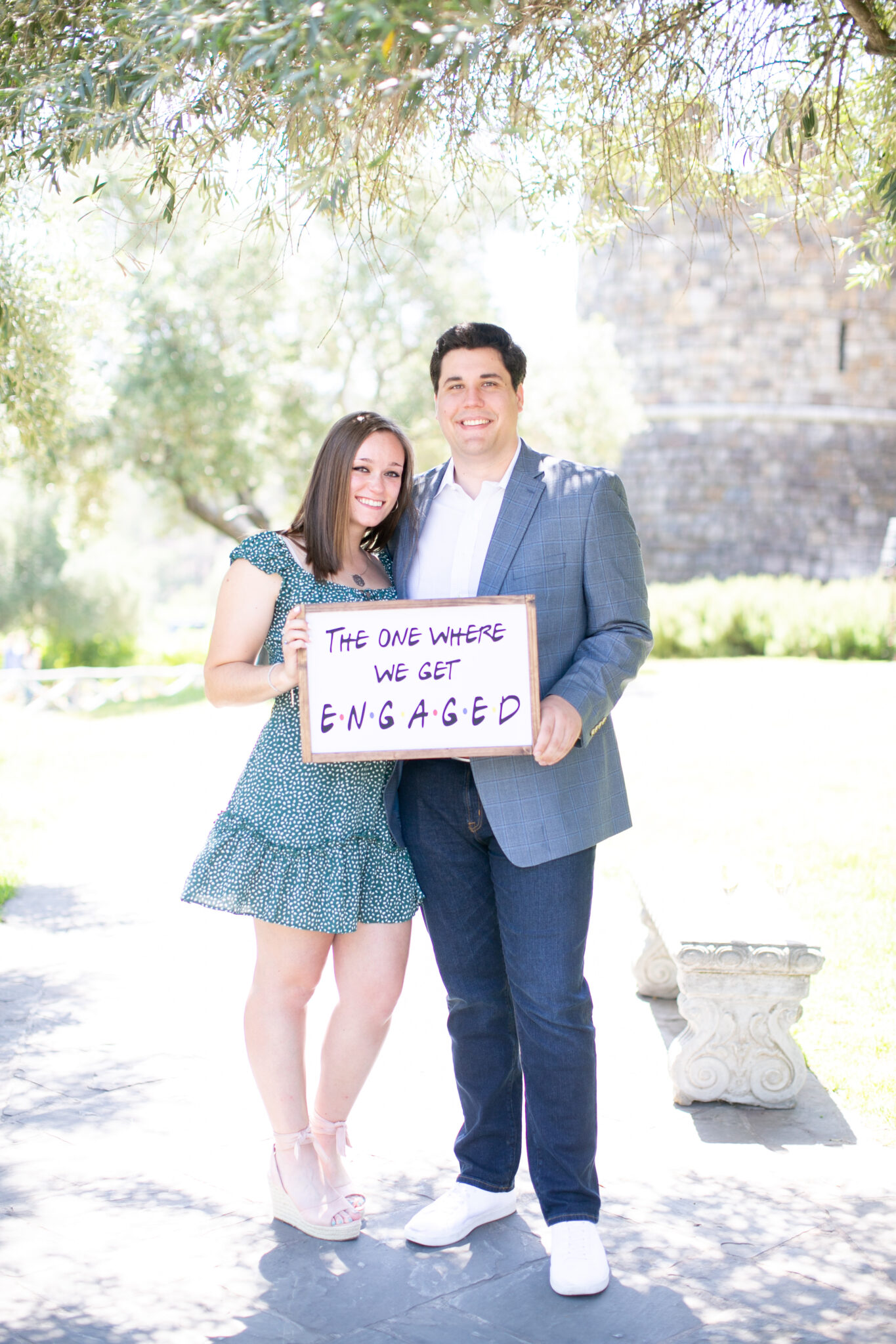 Couple holding friends themed sign after engagement