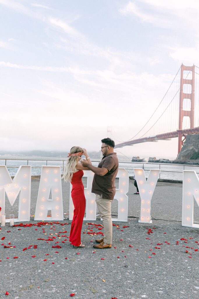 Man unblindfolding women in front of golden gate bridge