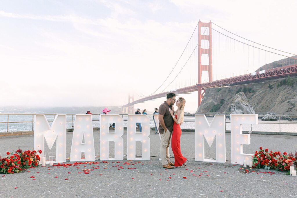 couple getting engaged in front of golden gate bridge