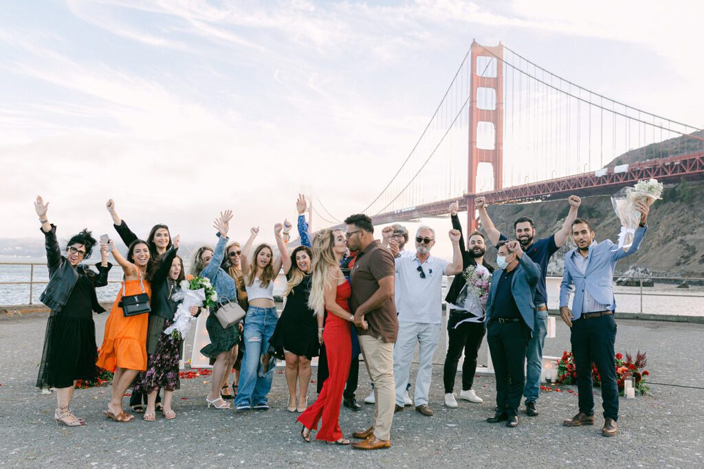 Family and friends celebrating proposal in front of golden gate bridge