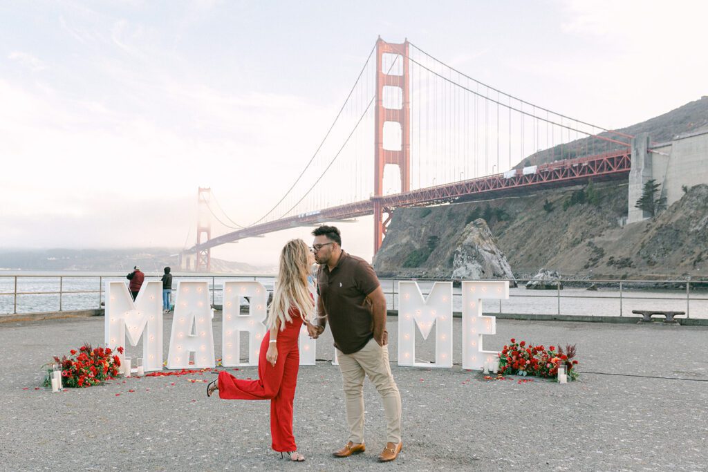 couple kissing in front of golden gate bridge