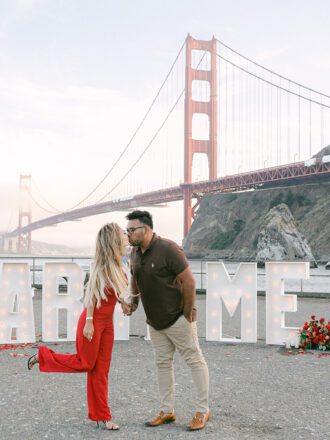 couple kissing in front of golden gate bridge