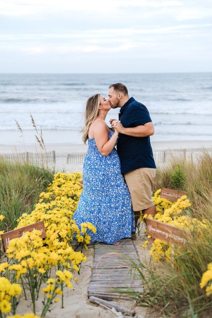 couple kissing in yellow daisies