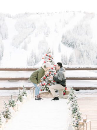 Man proposing in front of christmas tree