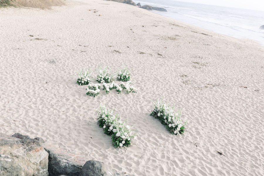 private luxury beach proposal half moon bay with flowers