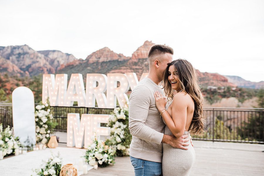 happy couple couple hugging proposal marry me letters sedona proposal