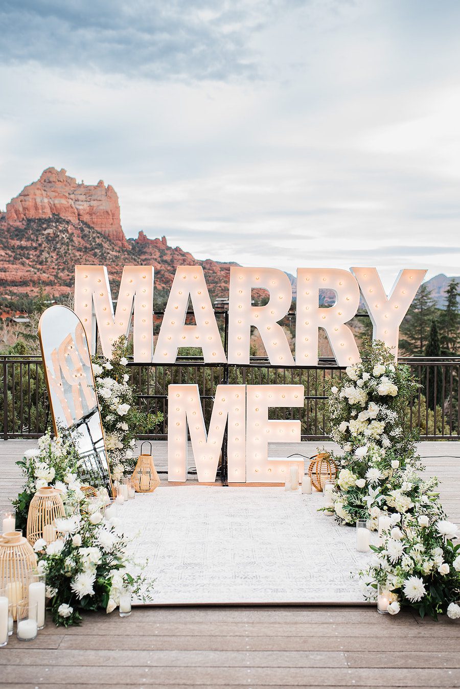 private concert proposal set up white flowers marry me marquee letters love letter mirror sedona proposal
