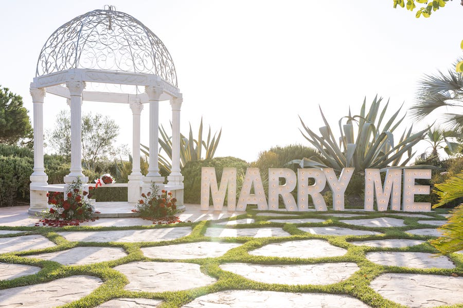 Gorgeous gazebo with red roses and marry me sign 
