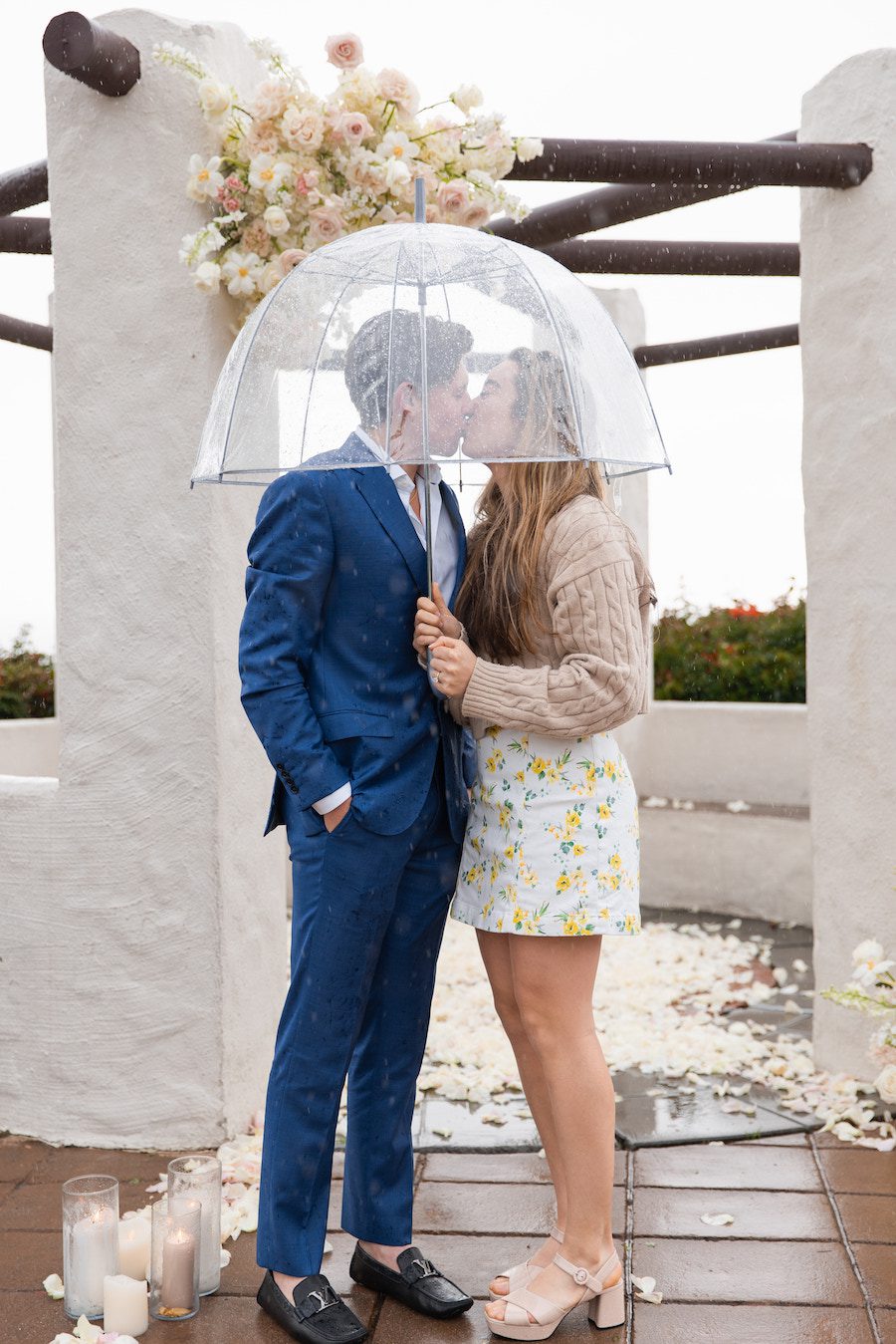 the couple enjoying their magical rainy day proposal set up
