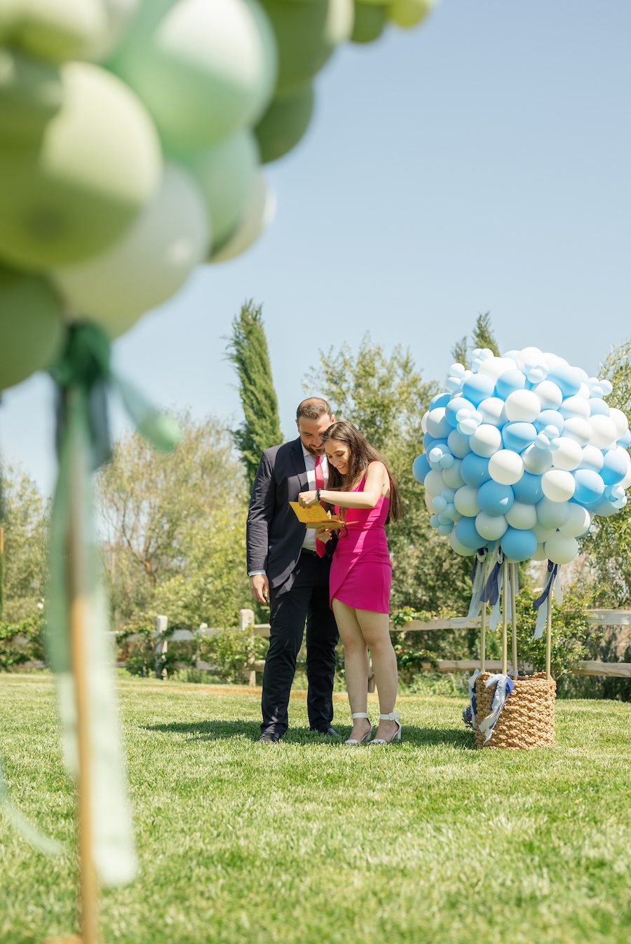 the couple reading the special notes at each balloon at this Hot air balloon inspired proposal in Malibu CA