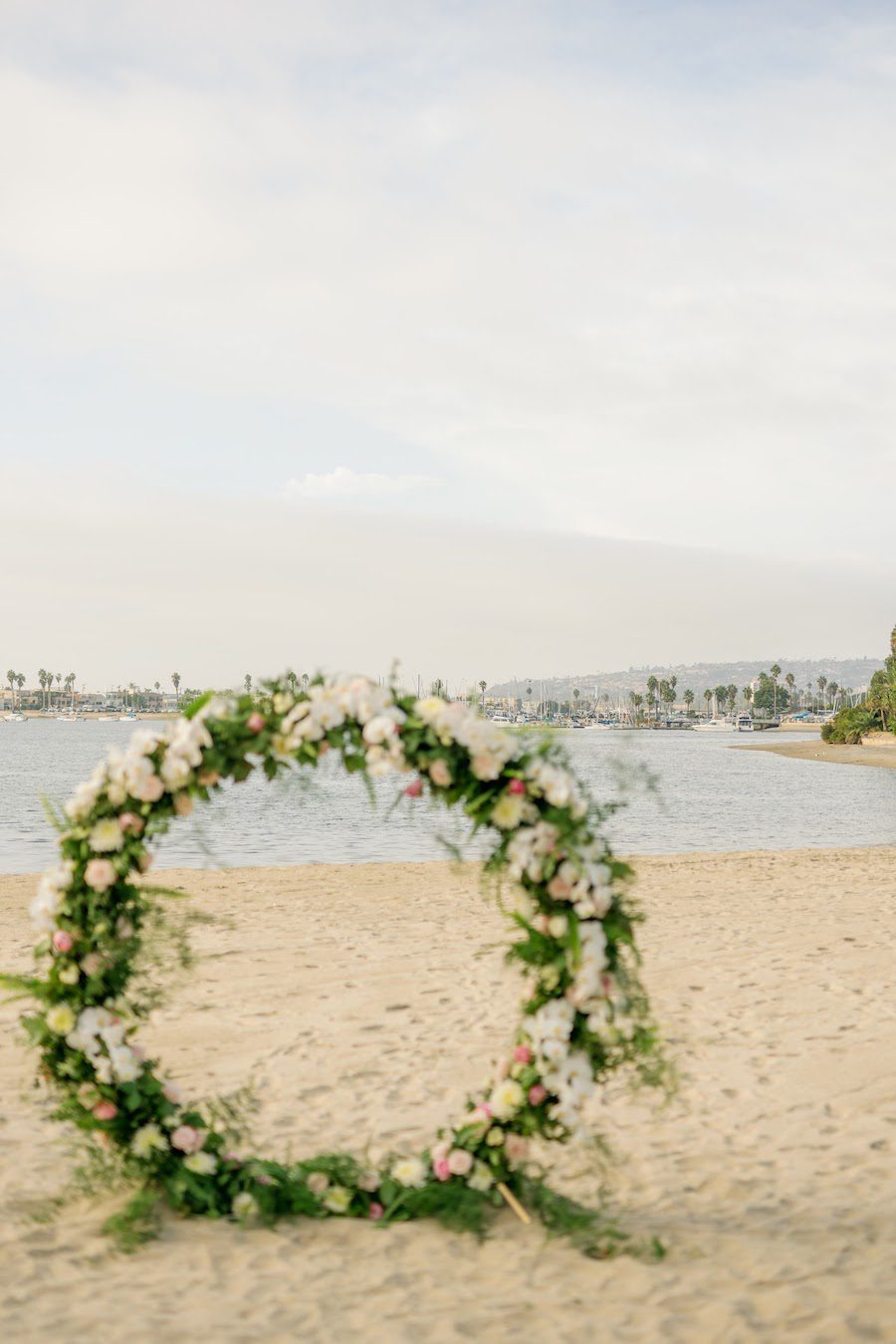 private beach proposal san diego with flower arch by the yes girls