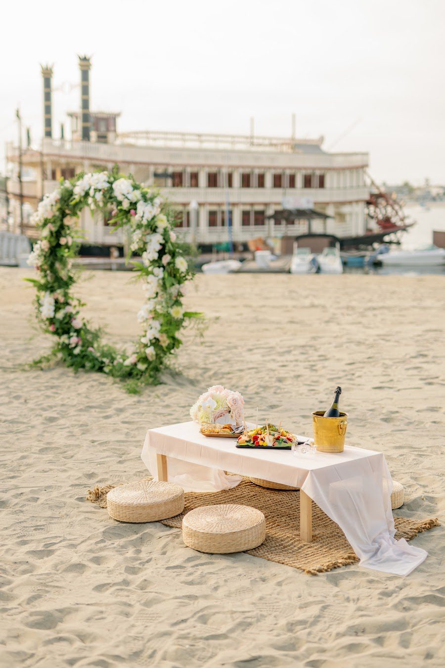 private beach proposal picnic san diego with flower arch by the yes girls