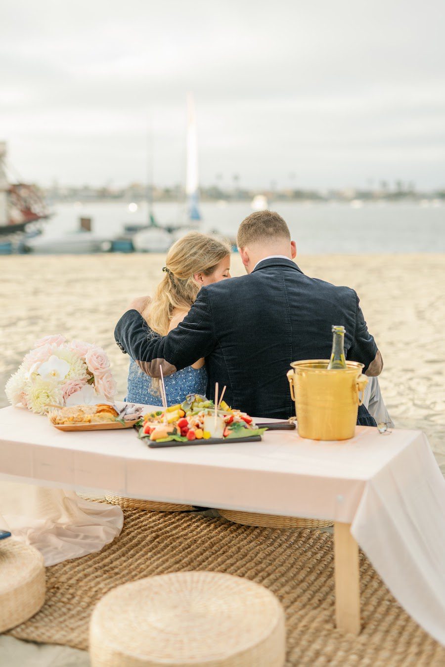 private beach proposal picnic san diego with flower arch by the yes girls