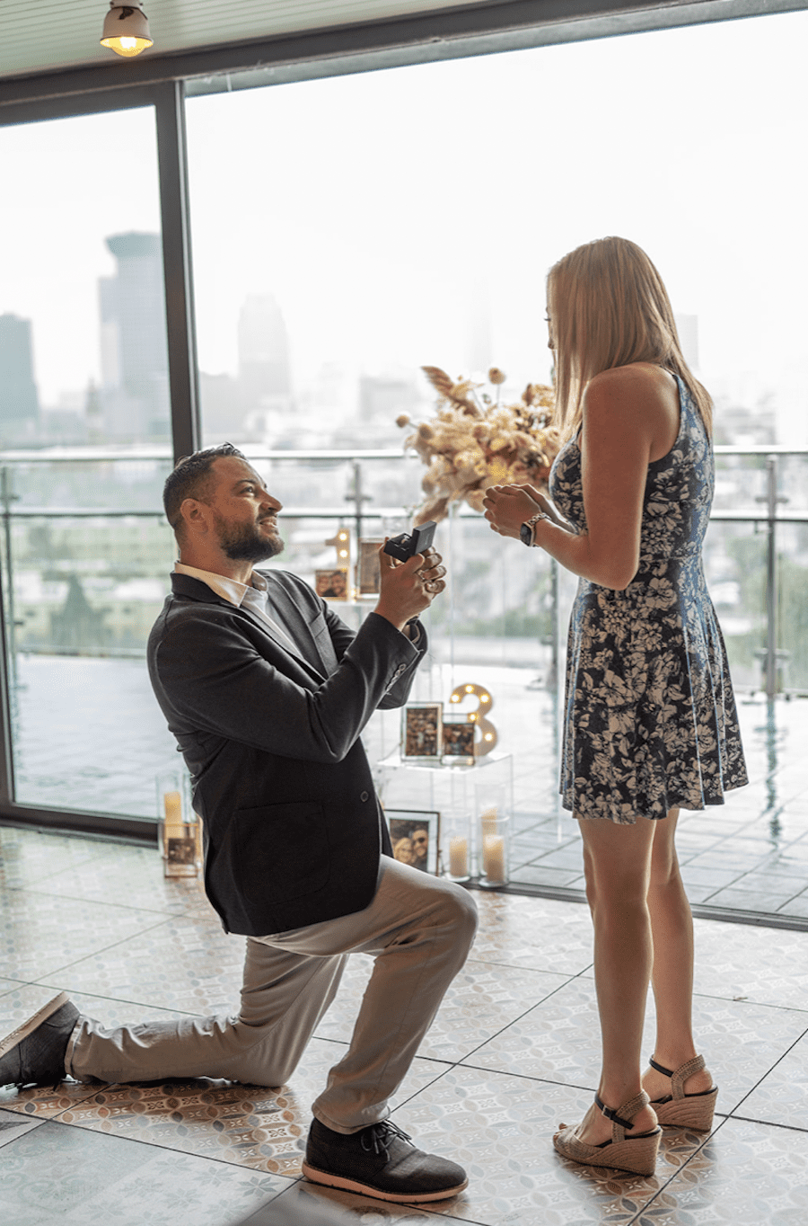 Romantic rooftop proposal in new orleans neutral florals. Down on one knee