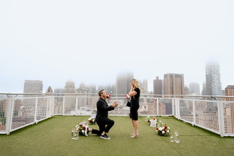 down on one knee luxury proposal nyc skyline proposal rooftop proposal red flower proposal