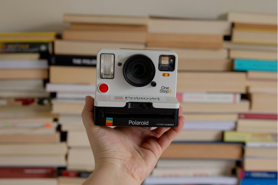 A person holding a Polaroid camera.