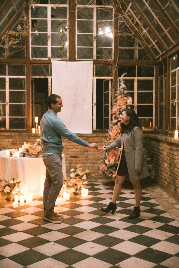 Intimate holiday proposal in Austin glasshouse with custom decor and romantic florals