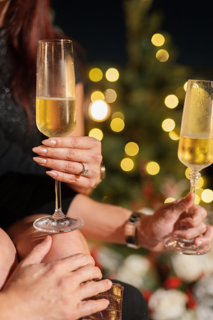 Holiday proposal surrounded by glowing Christmas trees and festive décor