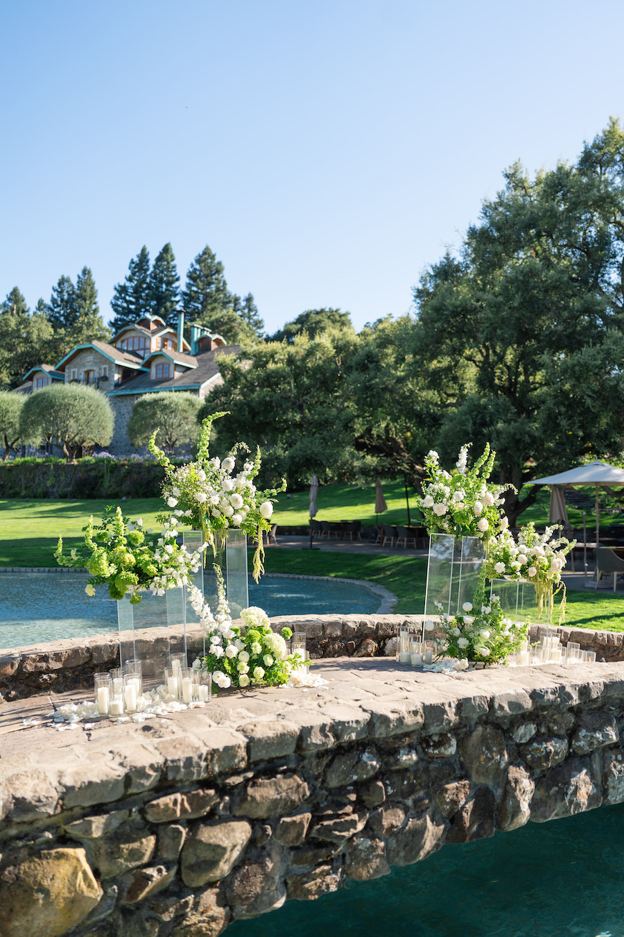 Scenic Napa winery proposal on a stone bridge with lush florals by The Yes Girls