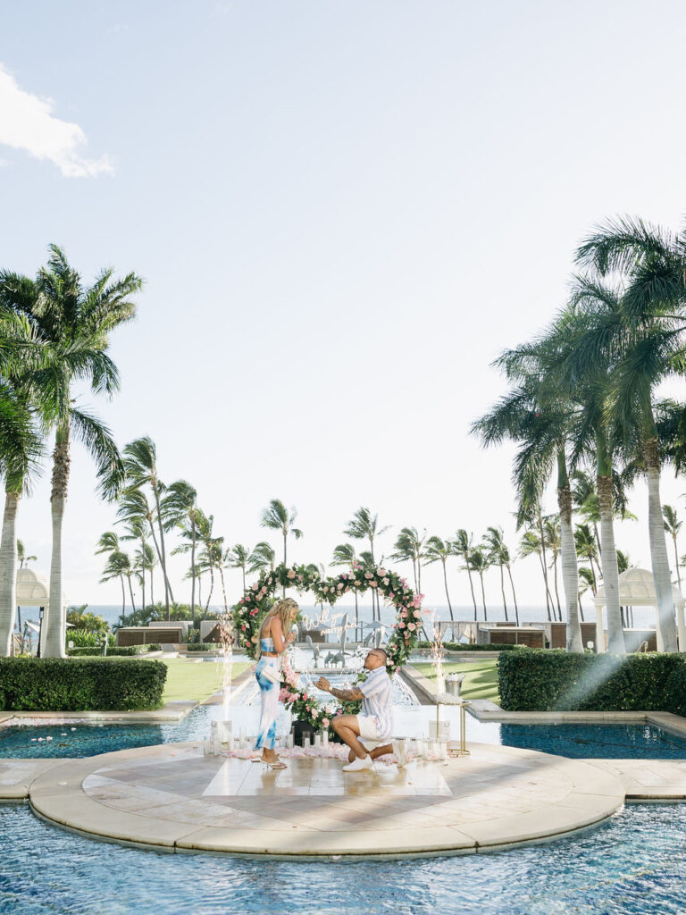 Heart floral arch on a poolside island surrounded by palm trees at the Grand Wailea