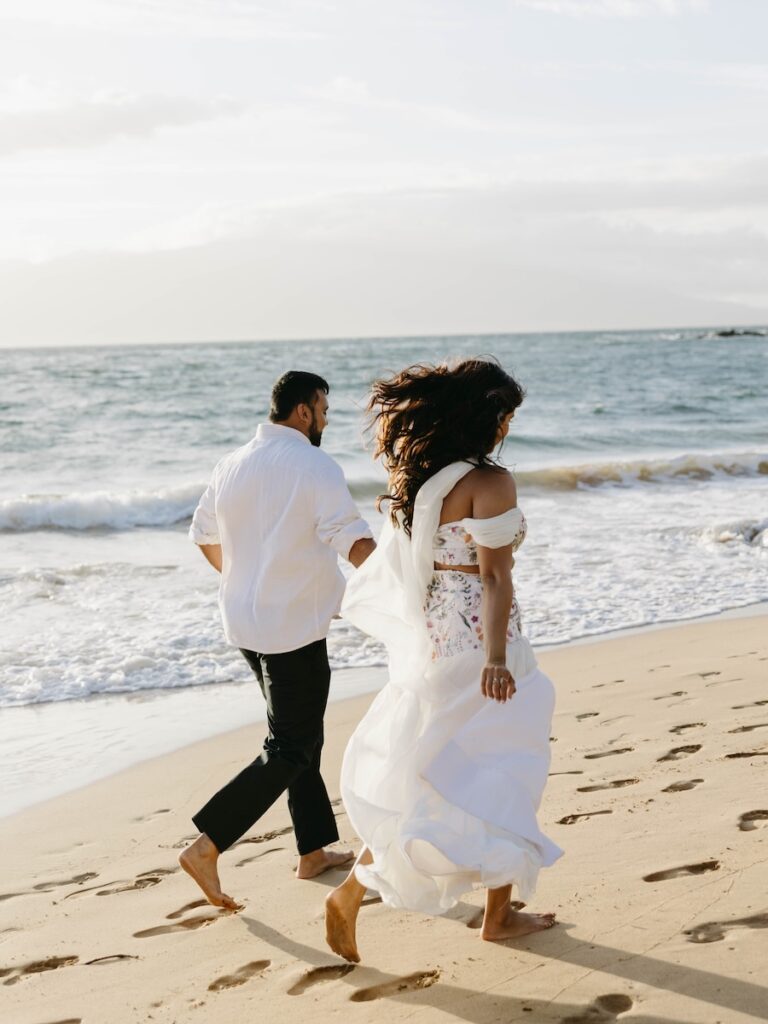 Couple running along the shoreline in Wailea after their Andaz Maui proposal