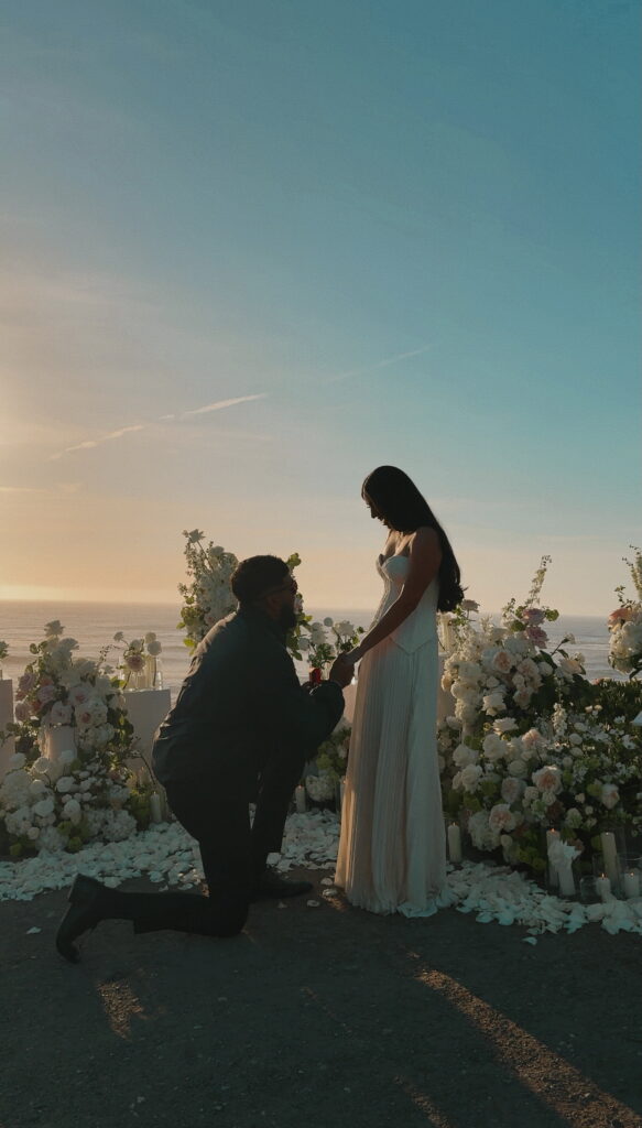 Bride and groom holding hands during sunset proposal