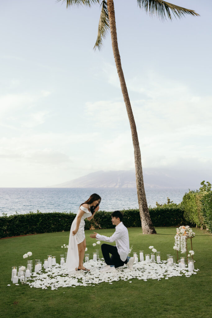 Beautiful outdoor proposal by the ocean with a romantic setup.