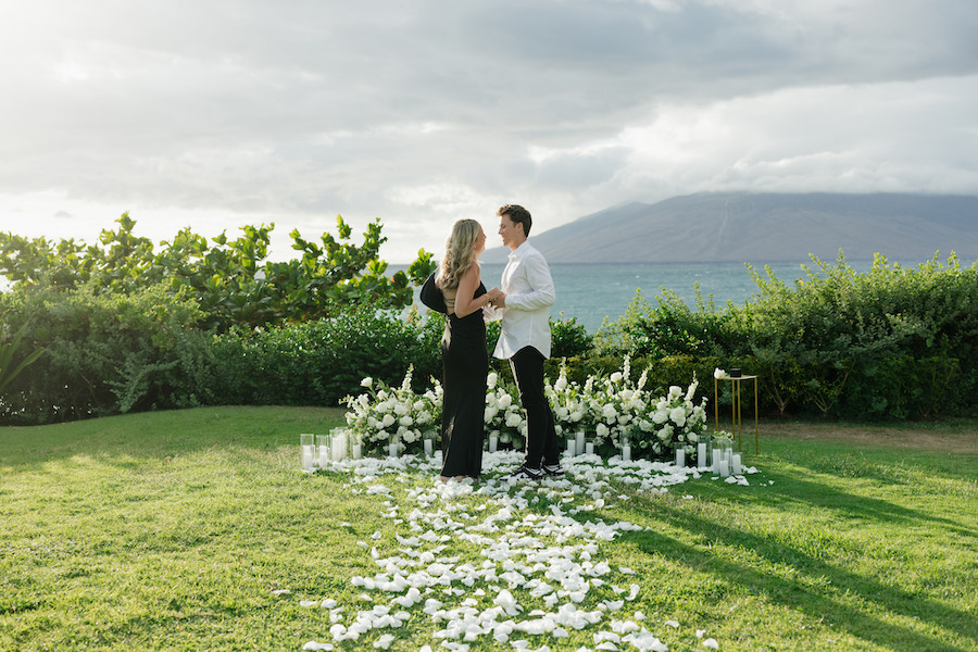 Elegant outdoor Maui proposal with couple on a grassy lawn.