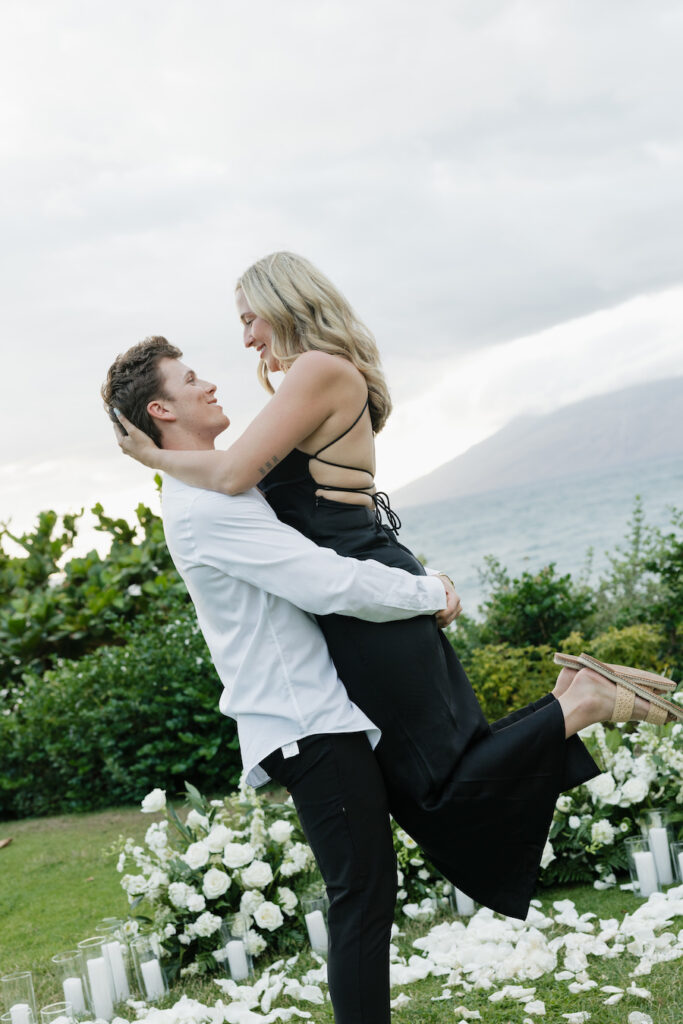 Zach and Amanda embracing outdoors during their engagement, with scenic nature background.