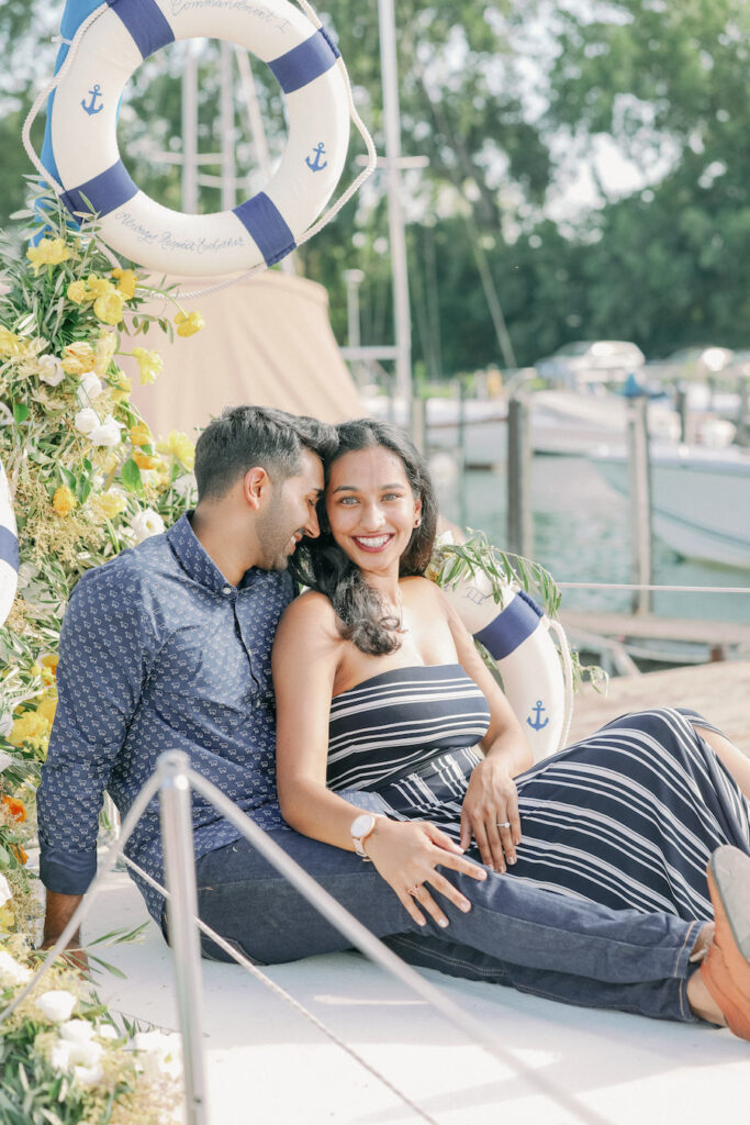 Beautiful couple enjoying a waterfront engagement session by the marina.