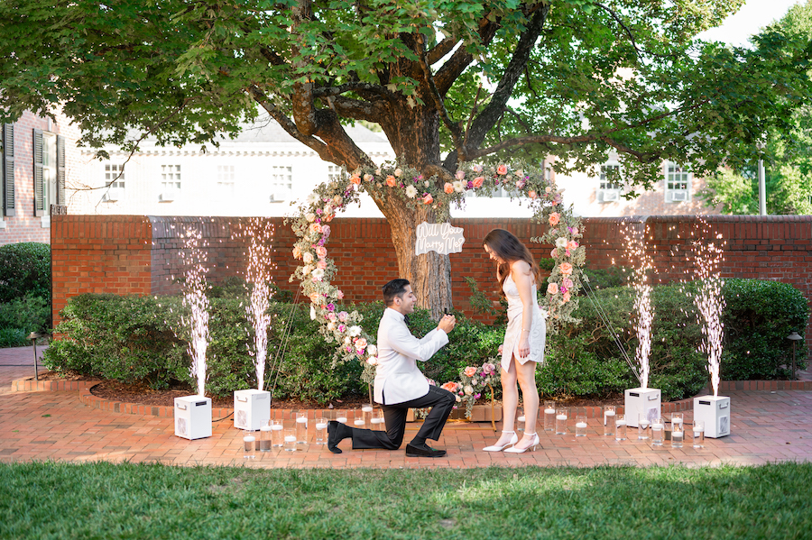 Proposal under a floral heart arch with sparklers at Riley & Kamran's proposal.