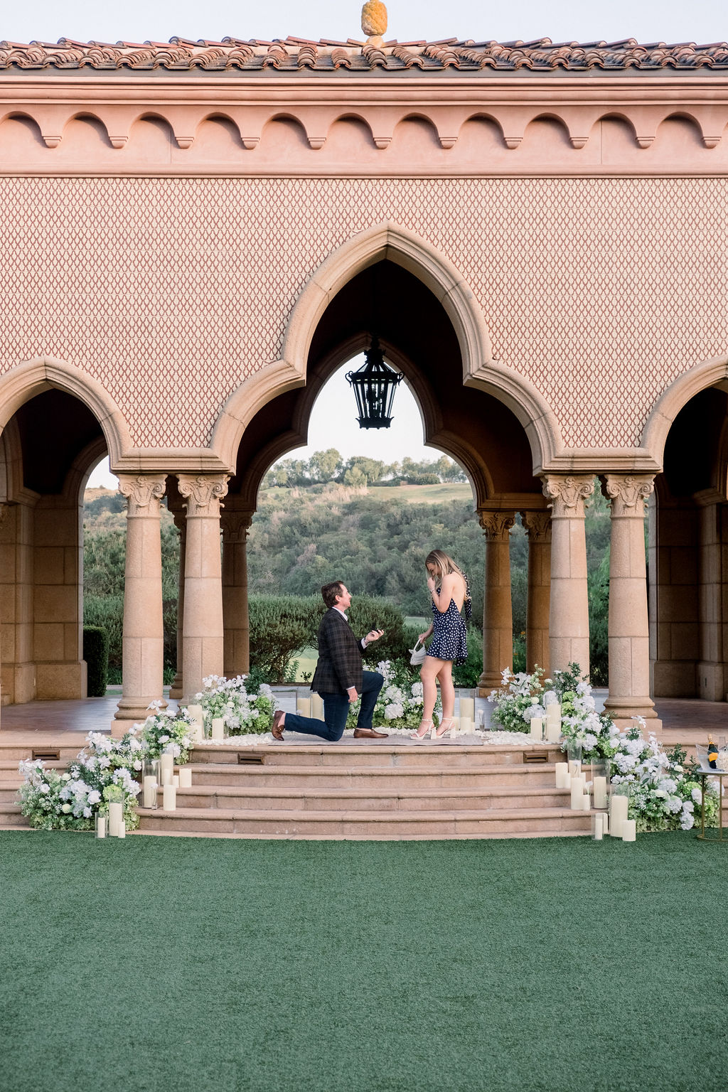 Man on one knee at a San Diego archway proposal at the Fairmont Grand Del Mar