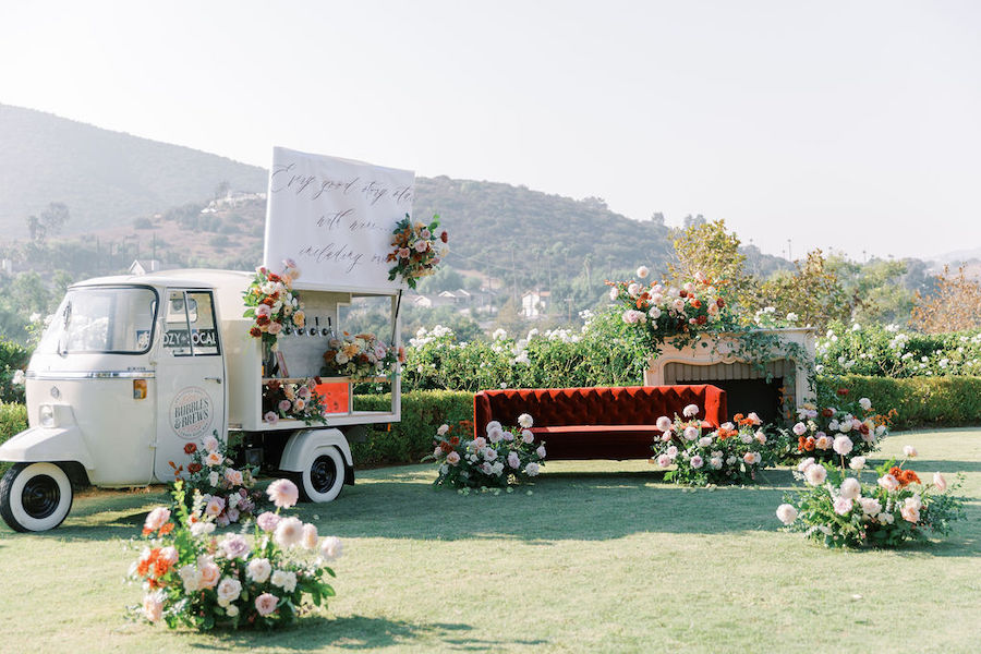Garden proposal setup with a red velvet sofa and florals overlooking the hills in San Diego